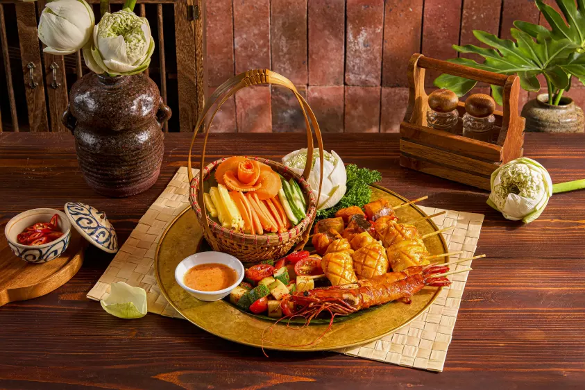 Grilled platter of squid and prawns with a basket of vegetables