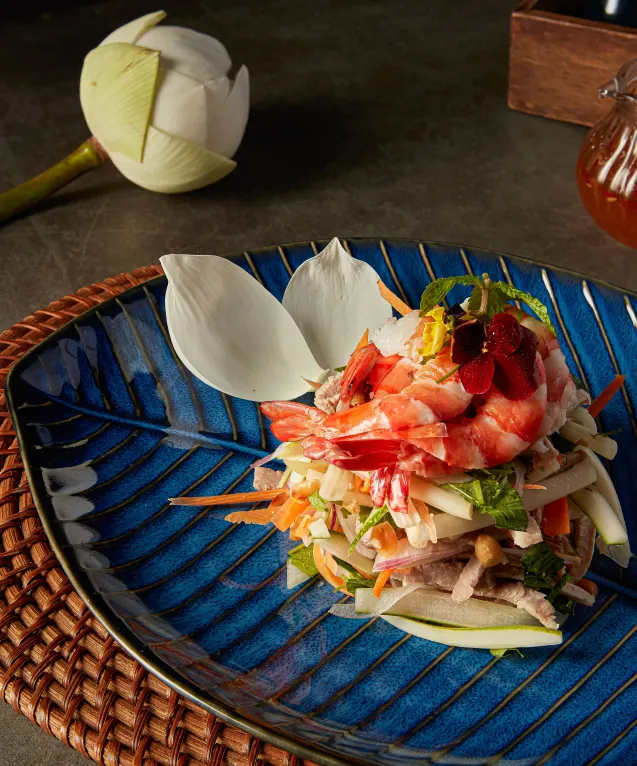 Seafood and shredded green salad stacked on a blue plate