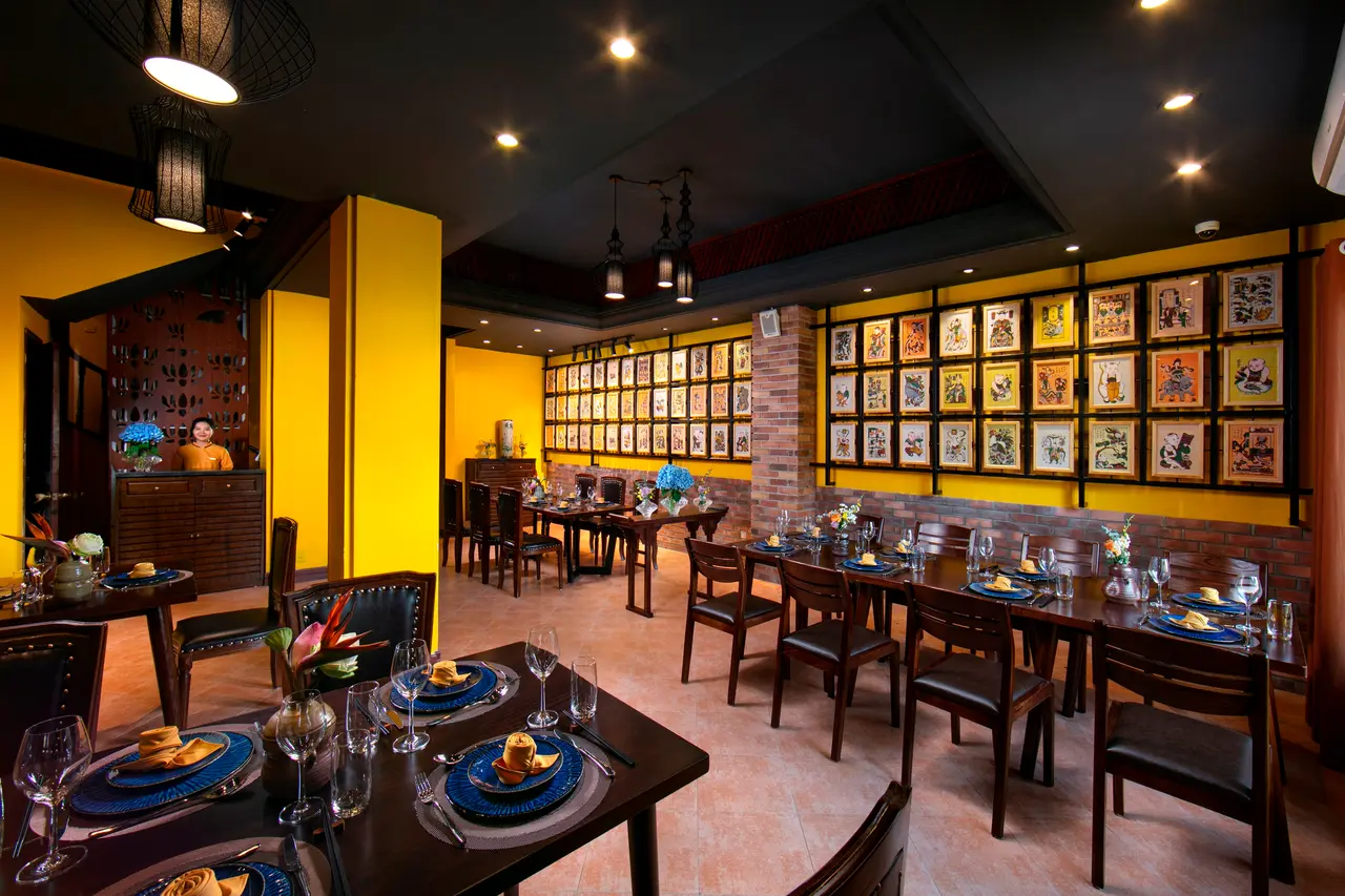 Dining room with framed prints on a yellow wall