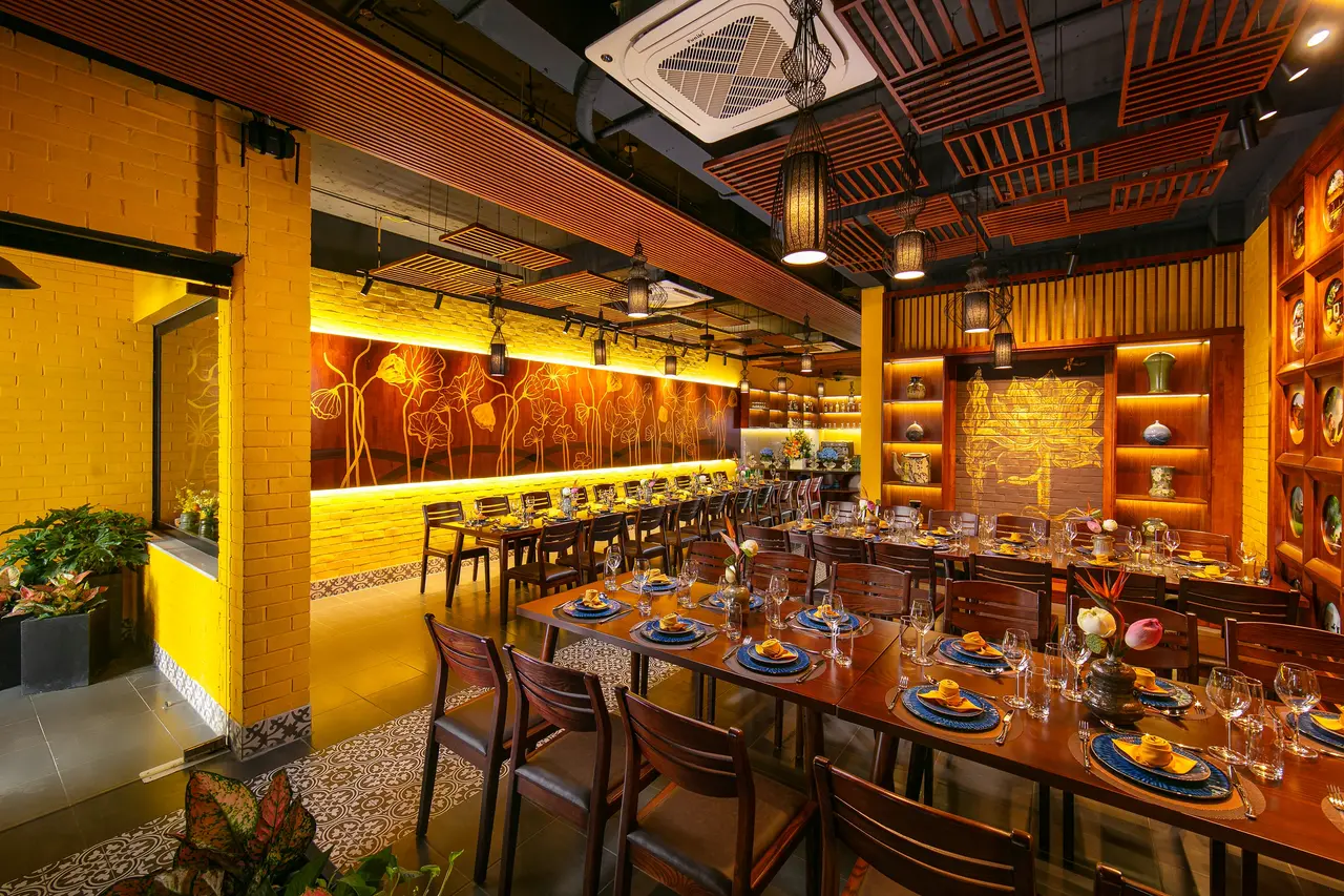 Dining hall with a golden lotus mural, lanterns and set tables