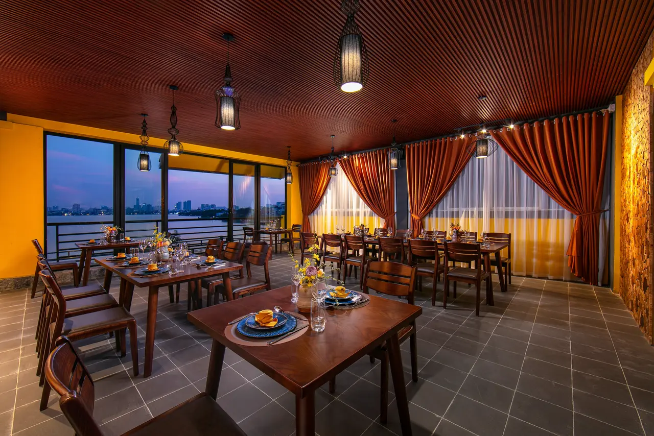 Long dining table beside large windows at dusk